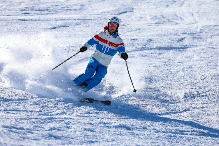 Man skiing down snowy slope in Vorarlberg, Austria, on a sunny winter day.